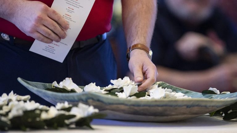 An attendee at a previous University Memorial Service places a flower in a bowl in memory of a loved one. This year’s service is set for 4 p.m. Thursday (May 1) in Paris Yates Chapel. Photo by Logan Kirkland/Ole Miss Digital Imaging Services